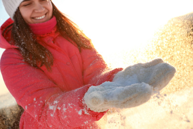 Photo of Young woman having fun outdoors on snowy winter day, closeup