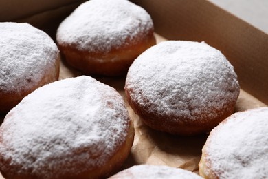 Delicious buns with powdered sugar in box, closeup