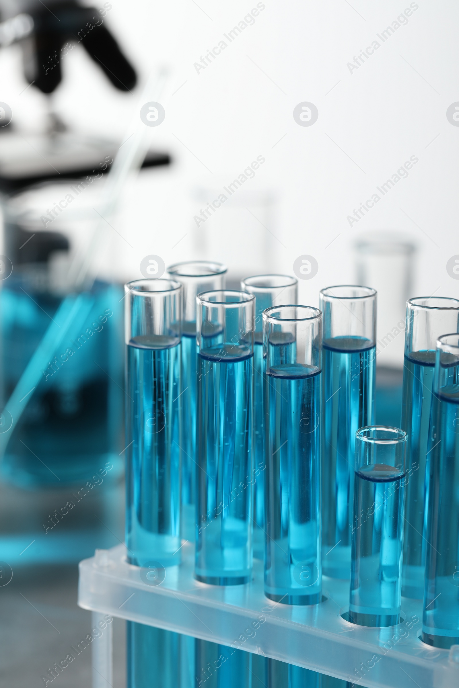 Photo of Test tubes with light blue liquid in laboratory, closeup