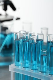 Photo of Test tubes with light blue liquid in laboratory, closeup