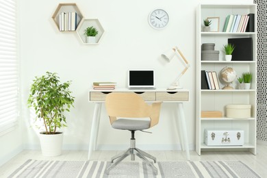 Beautiful workplace with comfortable desk and chair at home