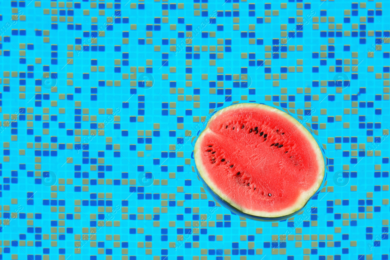 Half of fresh juicy watermelon in swimming pool, top view. Space for text Photo of Half of fresh juicy watermelon in swimming pool, top view. Space for text