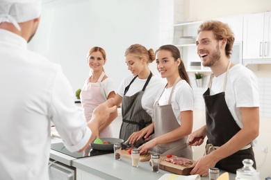 Group of people and male chef at cooking classes