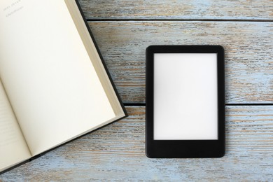 Photo of Portable e-book reader and hardcover book on wooden rustic table, flat lay