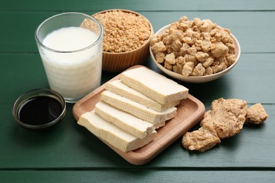 Different natural soy products on green wooden table