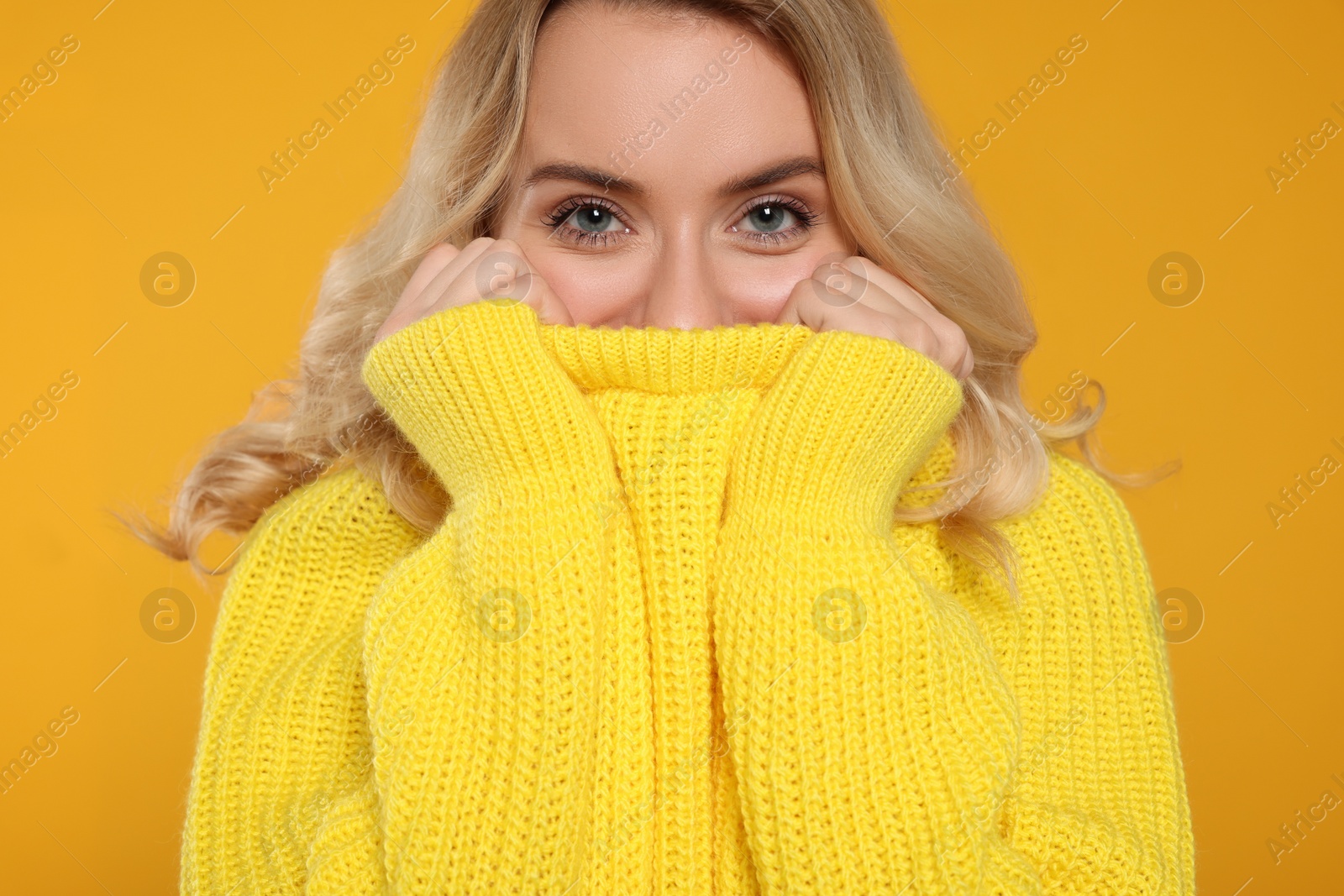 Photo of Beautiful woman in stylish warm sweater on orange background