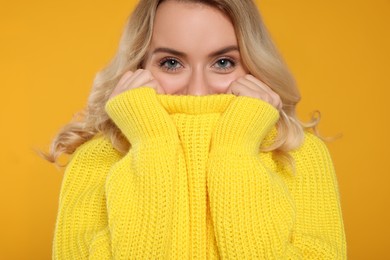 Photo of Beautiful woman in stylish warm sweater on orange background