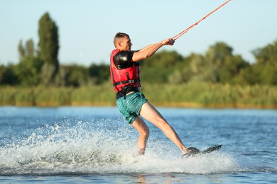 Photo of Man wakeboarding on river. Extreme water sport