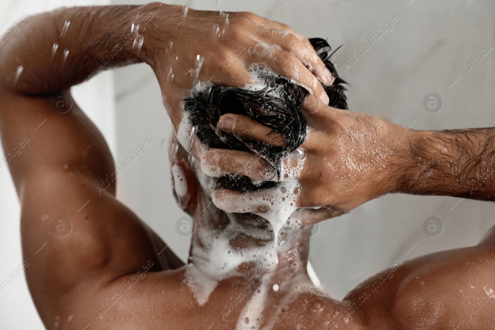 Photo of Man washing hair in shower at home, closeup