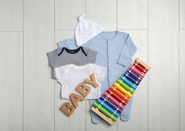 Flat lay composition with cute clothes on wooden background. Baby accessories