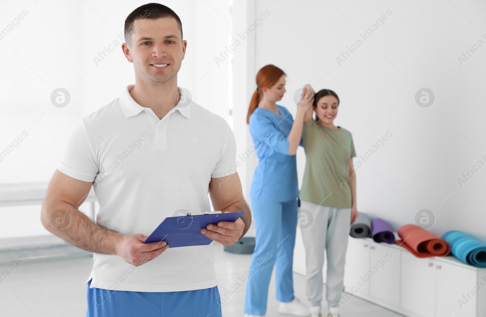 Photo of Portrait of professional physiotherapist with clipboard in rehabilitation center. Space for text