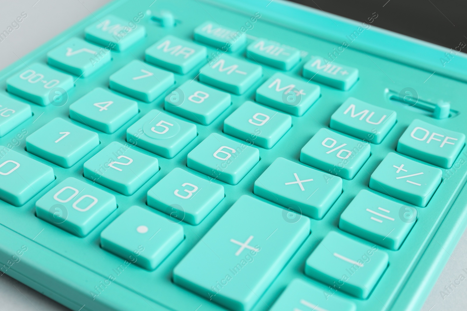 Photo of Closeup view of turquoise calculator on light background