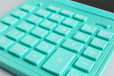 Closeup view of turquoise calculator on light background