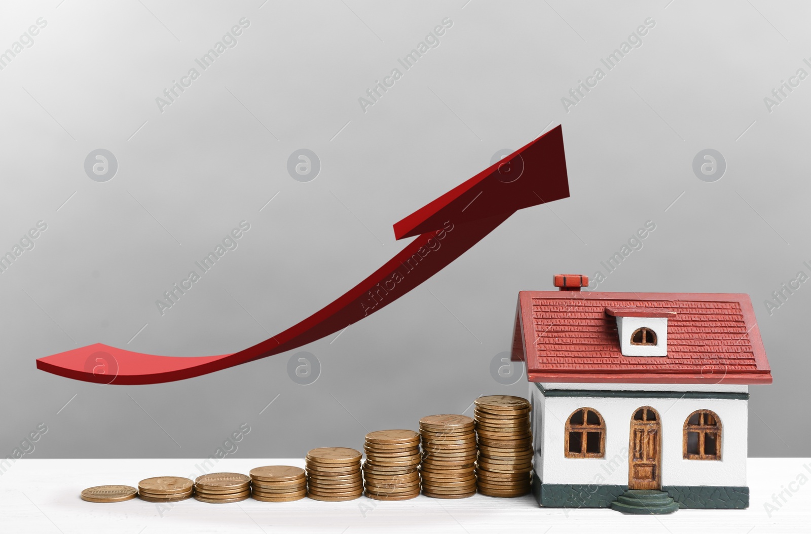 Image of Mortgage concept. House model and coins on white wooden table against light grey background 