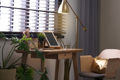 Photo of Stylish room interior with modern workplace at window