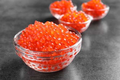 Photo of Glass bowl with delicious red caviar on table