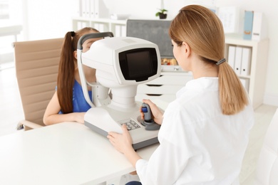 Ophthalmologist examining little girl in clinic