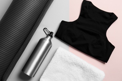 Stylish sportswear, bottle of water and yoga mat on color background, flat lay