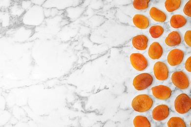 Photo of Flat lay composition with apricots on marble background, space for text. Dried fruit as healthy food