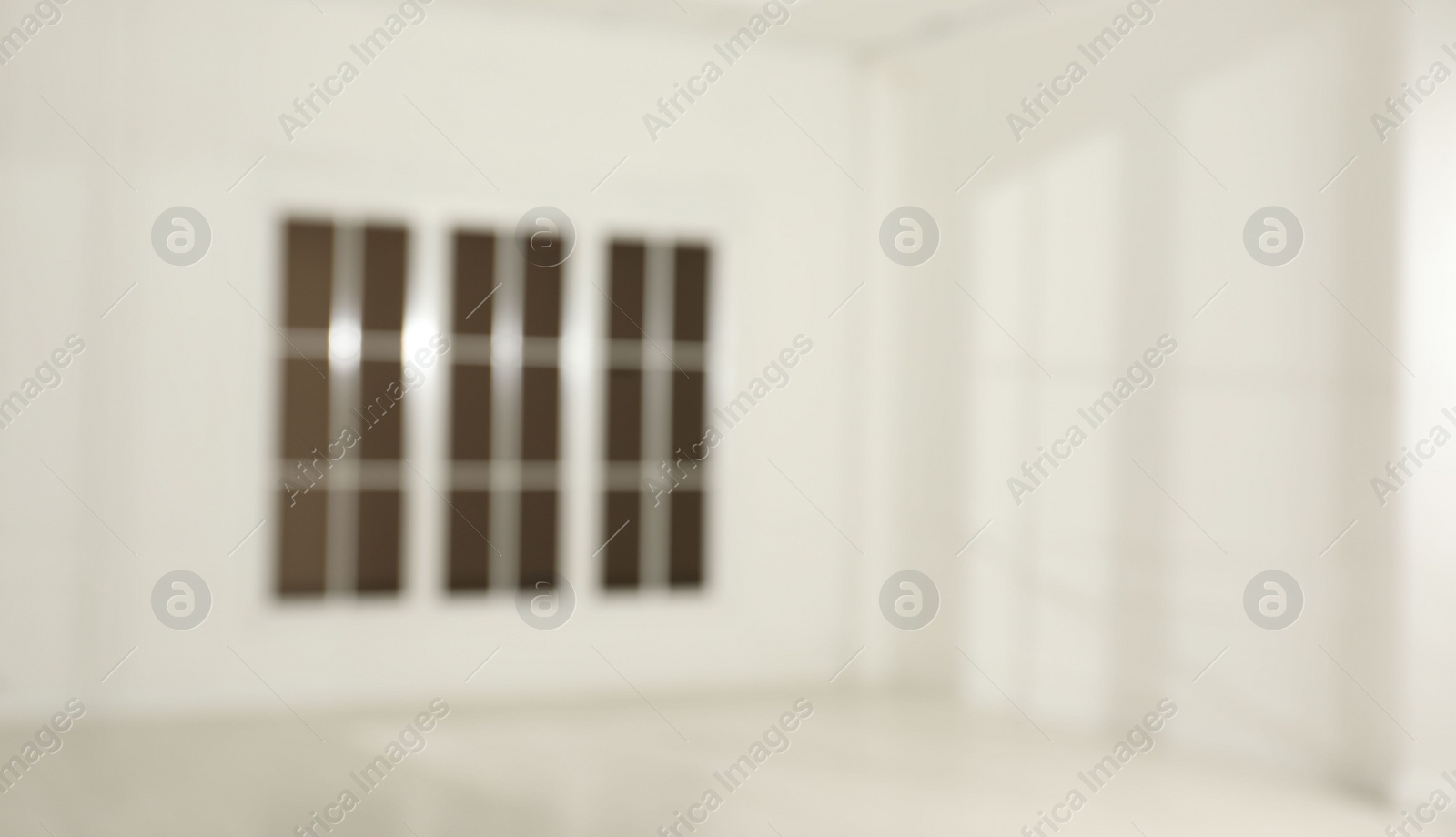 Photo of Empty room with white walls and large window, blurred view