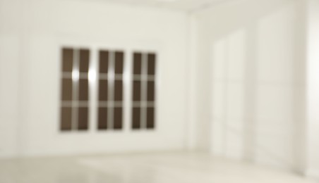 Empty room with white walls and large window, blurred view