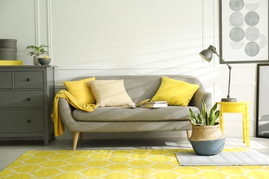 Photo of Stylish living room with sofa. Interior design in grey and yellow colors