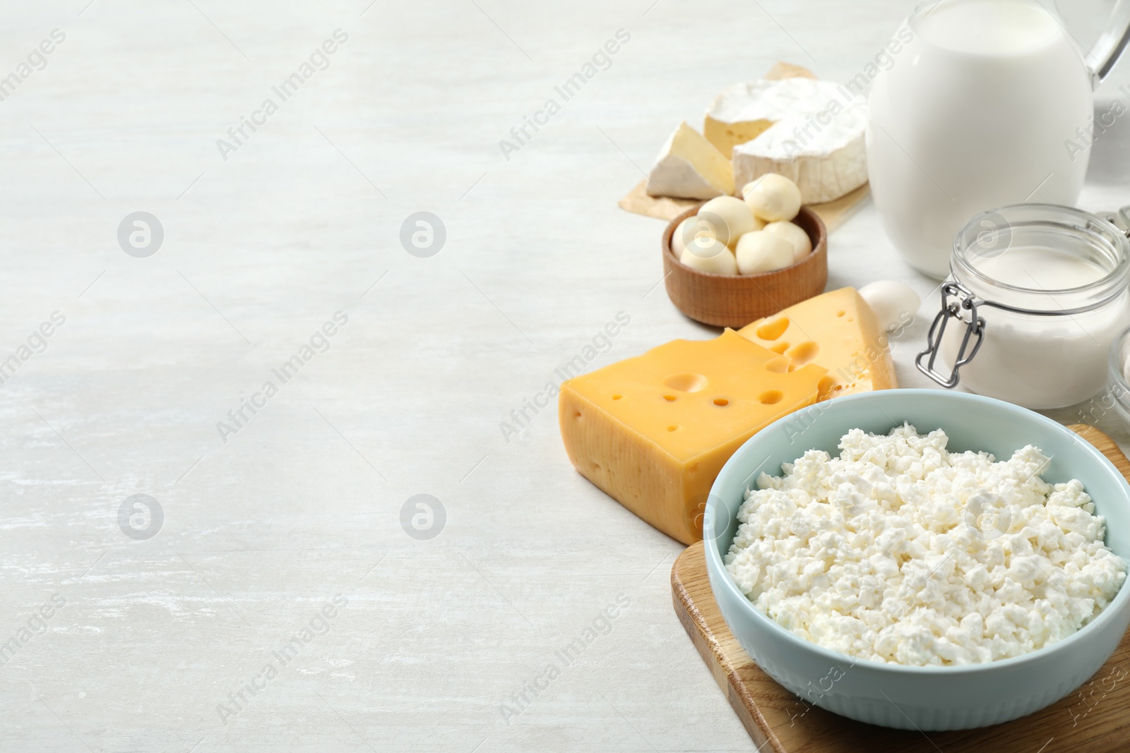 Photo of Different dairy products on white table. Space for text