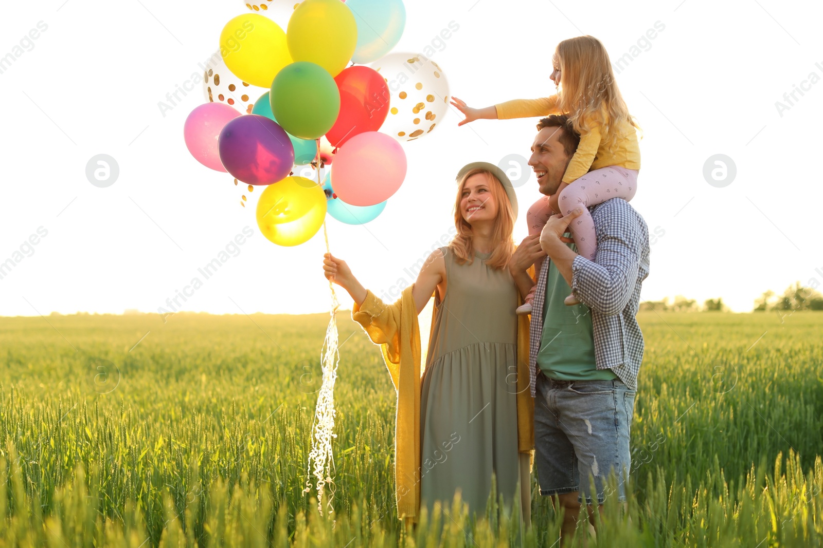 Photo of Happy family with colorful balloons outdoors on sunny day