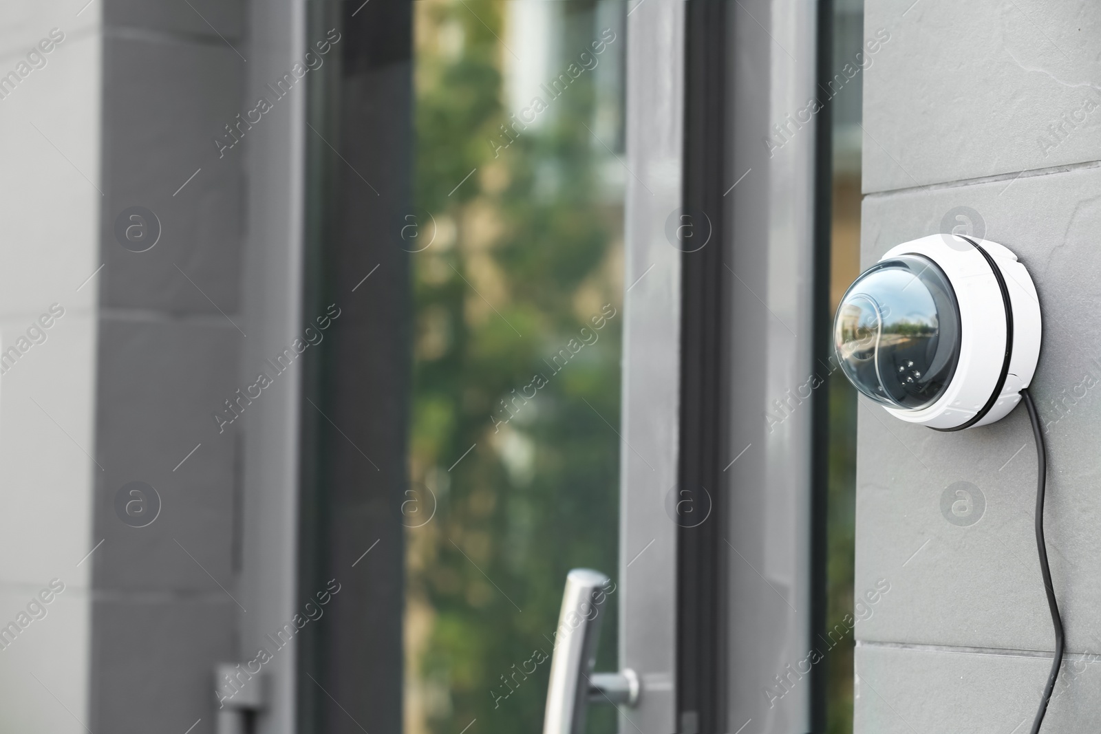 Photo of Modern security CCTV camera on wall outdoors