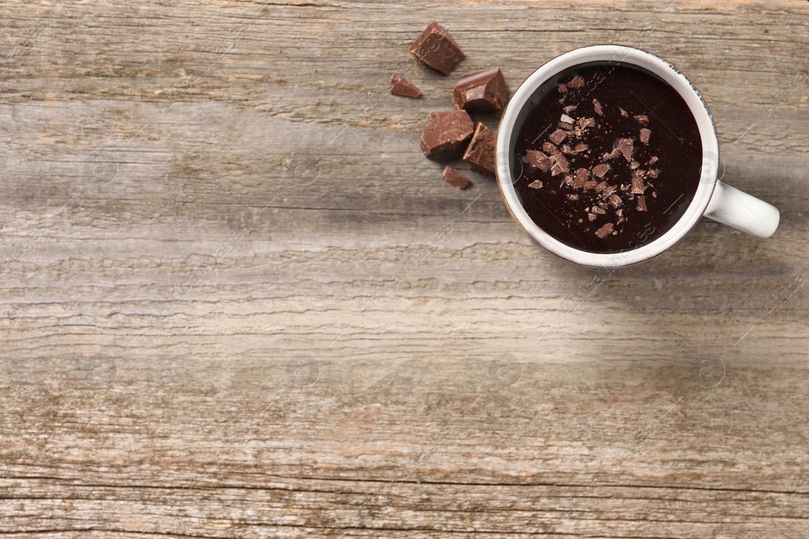 Photo of Yummy hot chocolate in cup on wooden table, flat lay. Space for text