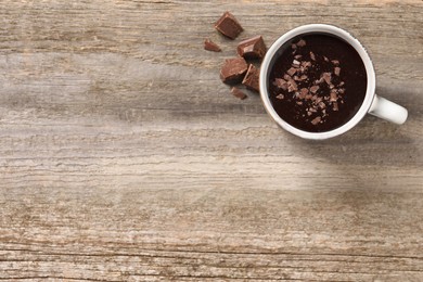 Photo of Yummy hot chocolate in cup on wooden table, flat lay. Space for text