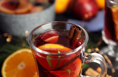 Photo of Tasty mulled wine with spices on table, closeup