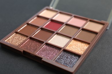 Photo of Colorful eyeshadow palette on dark background, closeup