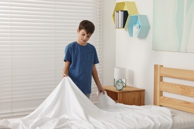 Photo of Boy changing bed linens in children room