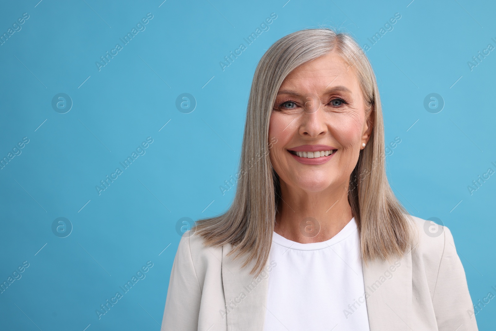 Photo of Portrait of beautiful middle aged woman on light blue background, space for text