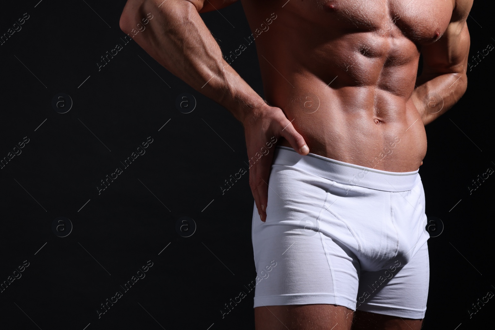 Photo of Young man in stylish white underwear on black background, closeup. Space for text