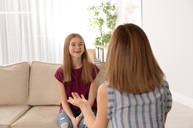 Photo of Mother talking with her teenager daughter at home