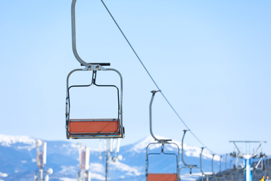 Empty chairlift at mountain ski resort, space for text. Winter vacation