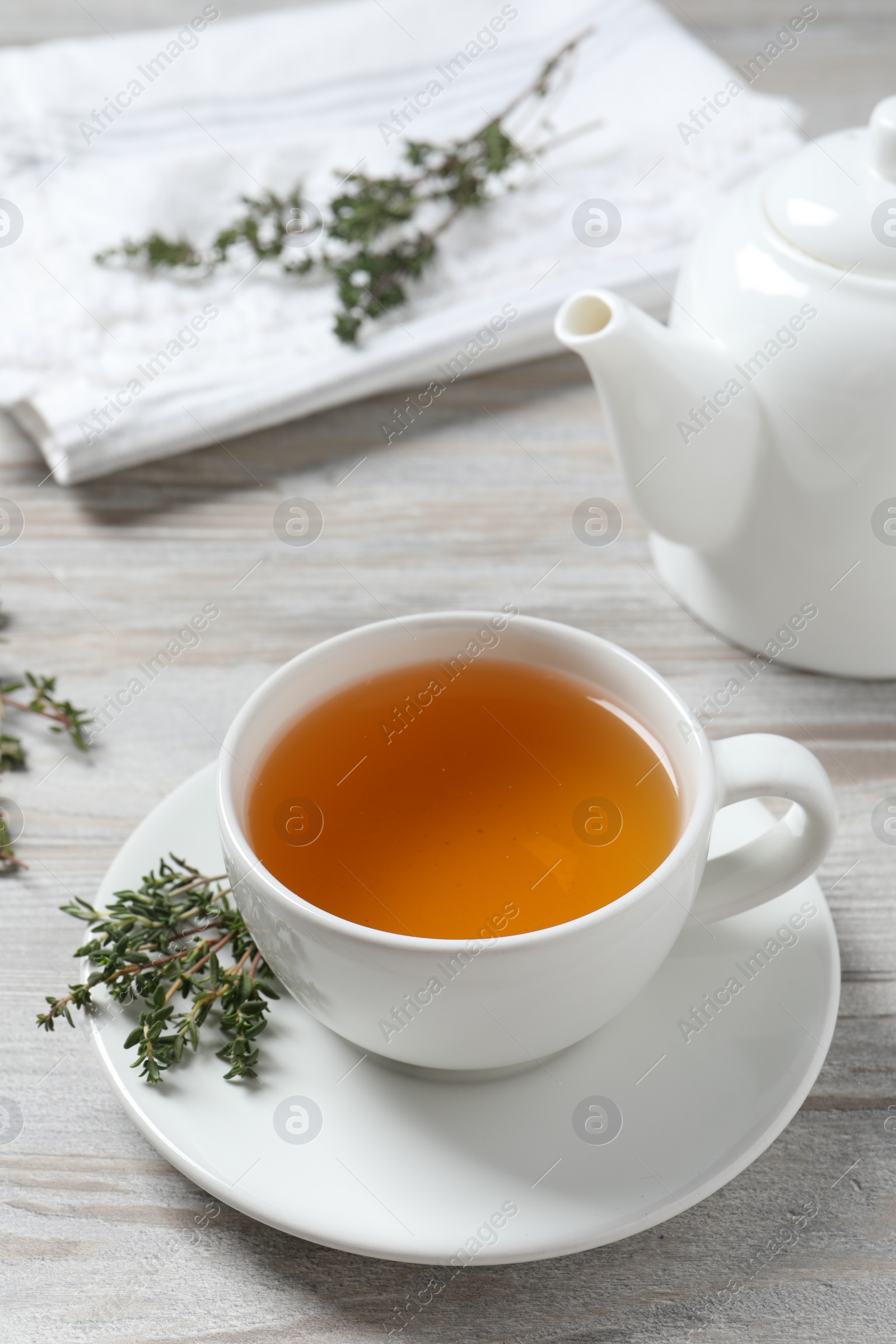 Photo of Aromatic herbal tea with thyme on white wooden table