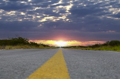 Image of Empty asphalt road at sunrise, closeup view