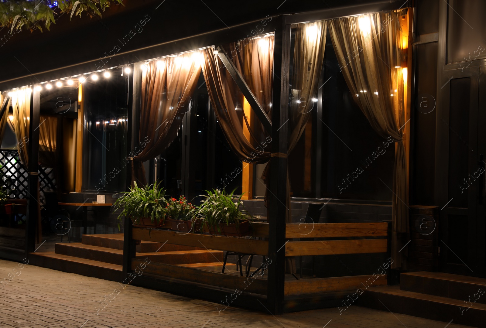 Photo of Beautiful view of modern cafe with outdoor terrace at night