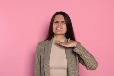 Photo of Emotional young woman on pink background. Aggression concept