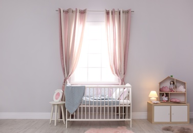 Baby room interior with comfortable crib and dollhouse