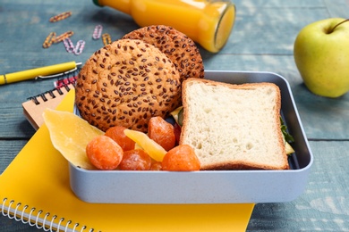 Photo of Lunch box with appetizing food and stationery on table