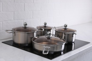 Photo of Set of new clean cookware on cooktop in kitchen