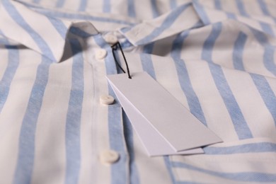 Blank white tags on striped shirt, closeup. Space for text