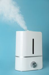 Photo of Modern air humidifier on light blue background