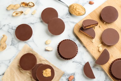 Photo of Flat lay composition with delicious peanut butter cups on white marble table