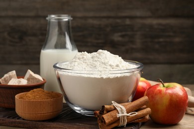 Photo of Flour, milk and different ingredients on wooden table. Cooking yeast cake