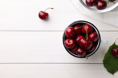 Fresh red ripe cherries with water drops on white wooden table, flat lay. Space for text